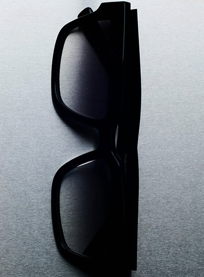 Black sunglasses on a gray textured surface