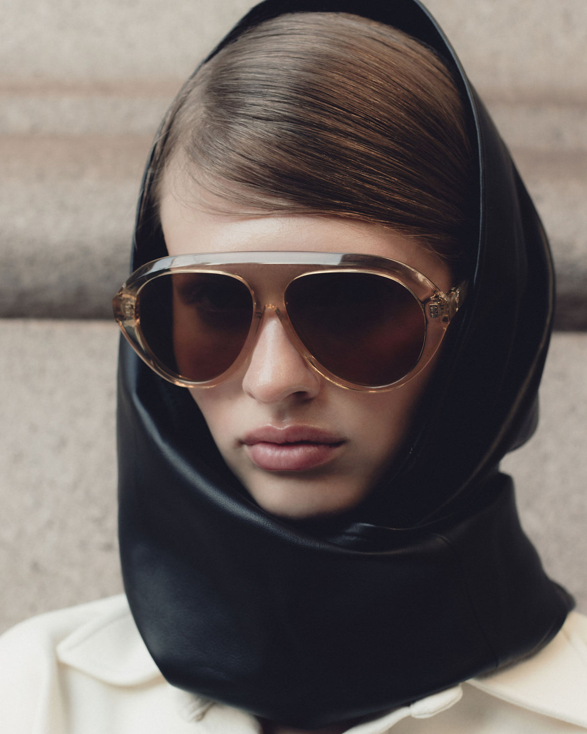 Model in a black leather hood wearing Past Midnight The Icon Retrofête Ochre sunglasses with amber lenses