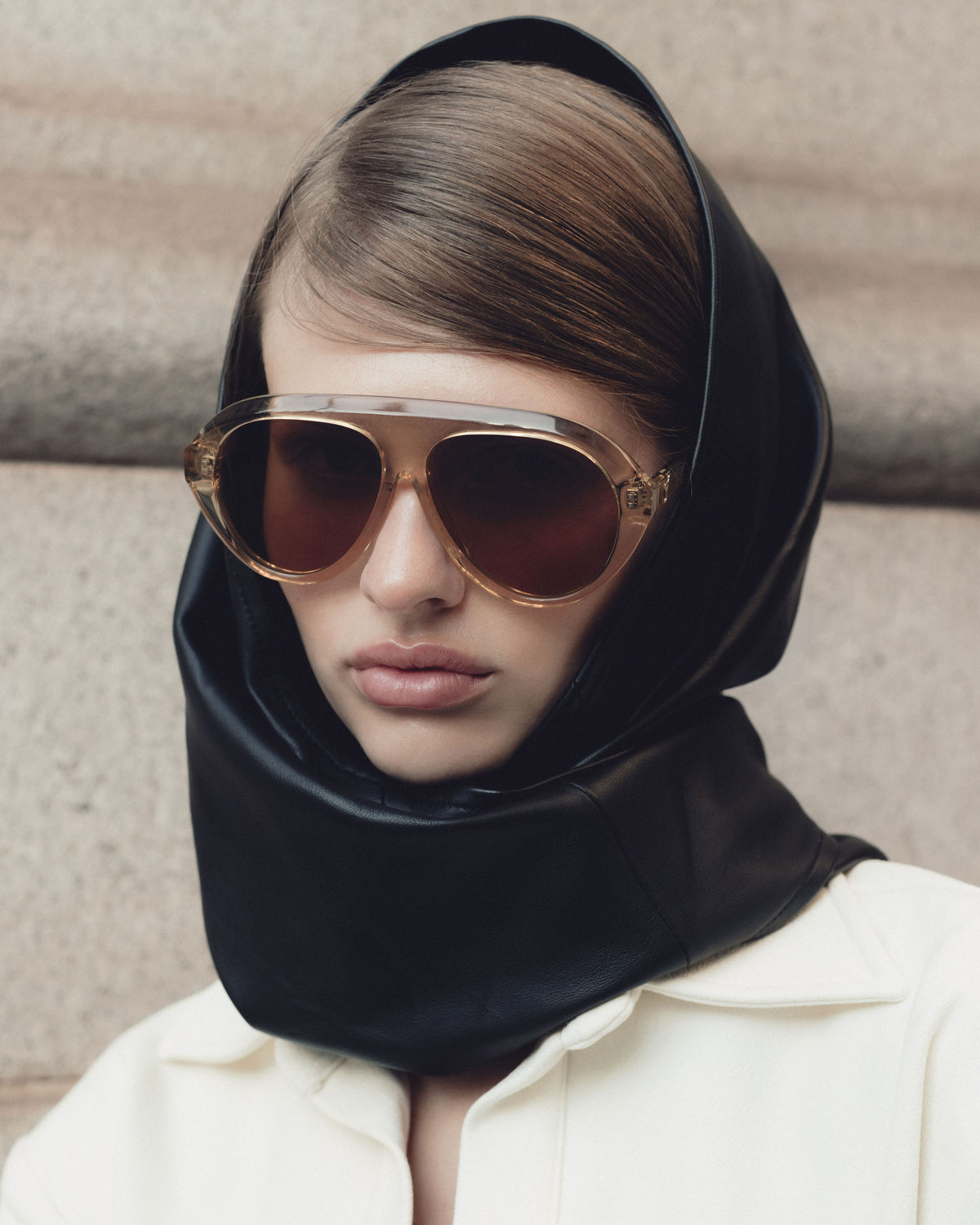 Model in a black leather hood wearing Past Midnight The Icon Retrofête Ochre sunglasses with amber lenses